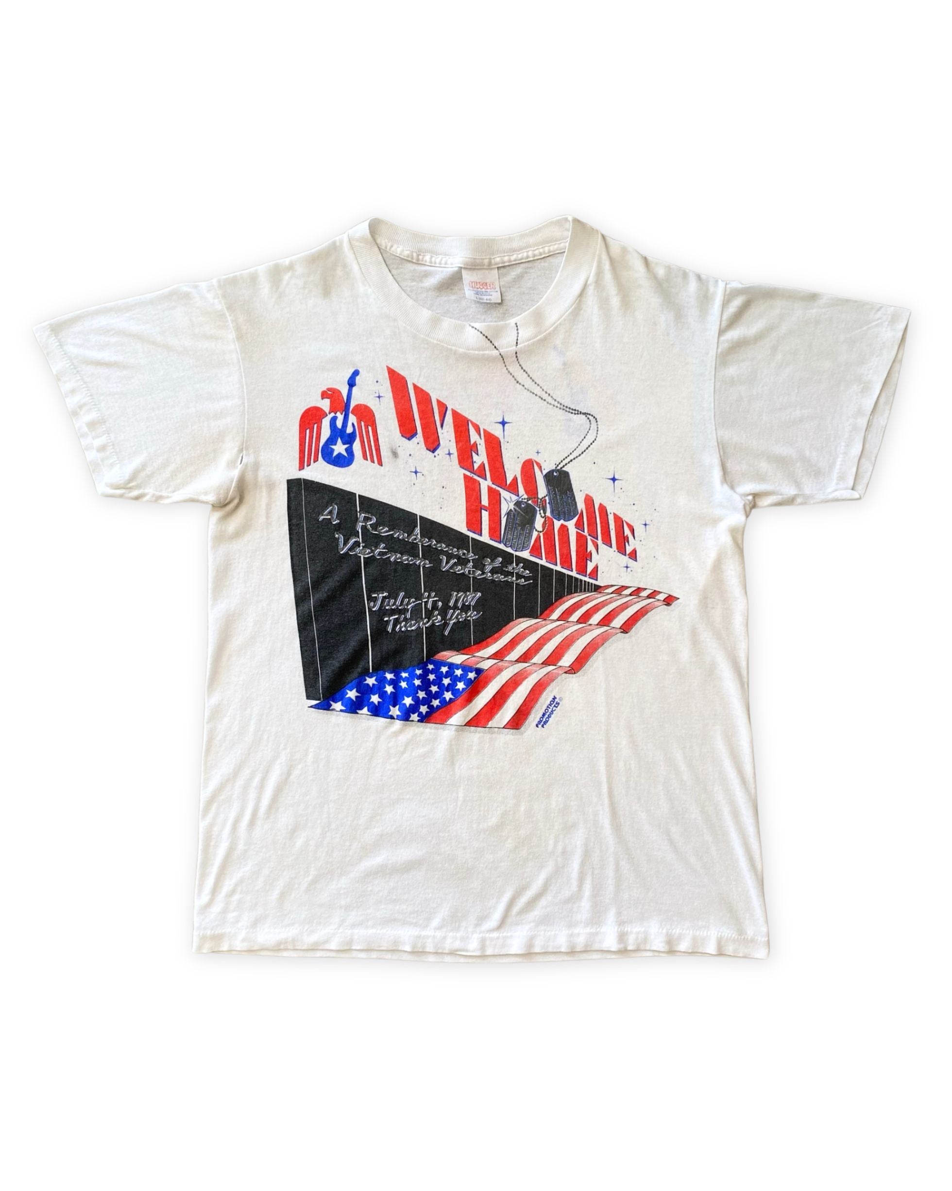 Front of vintage 1987 Vietnam Veterans Welcome Home concert T-shirt featuring patriotic graphics and musician lineup.