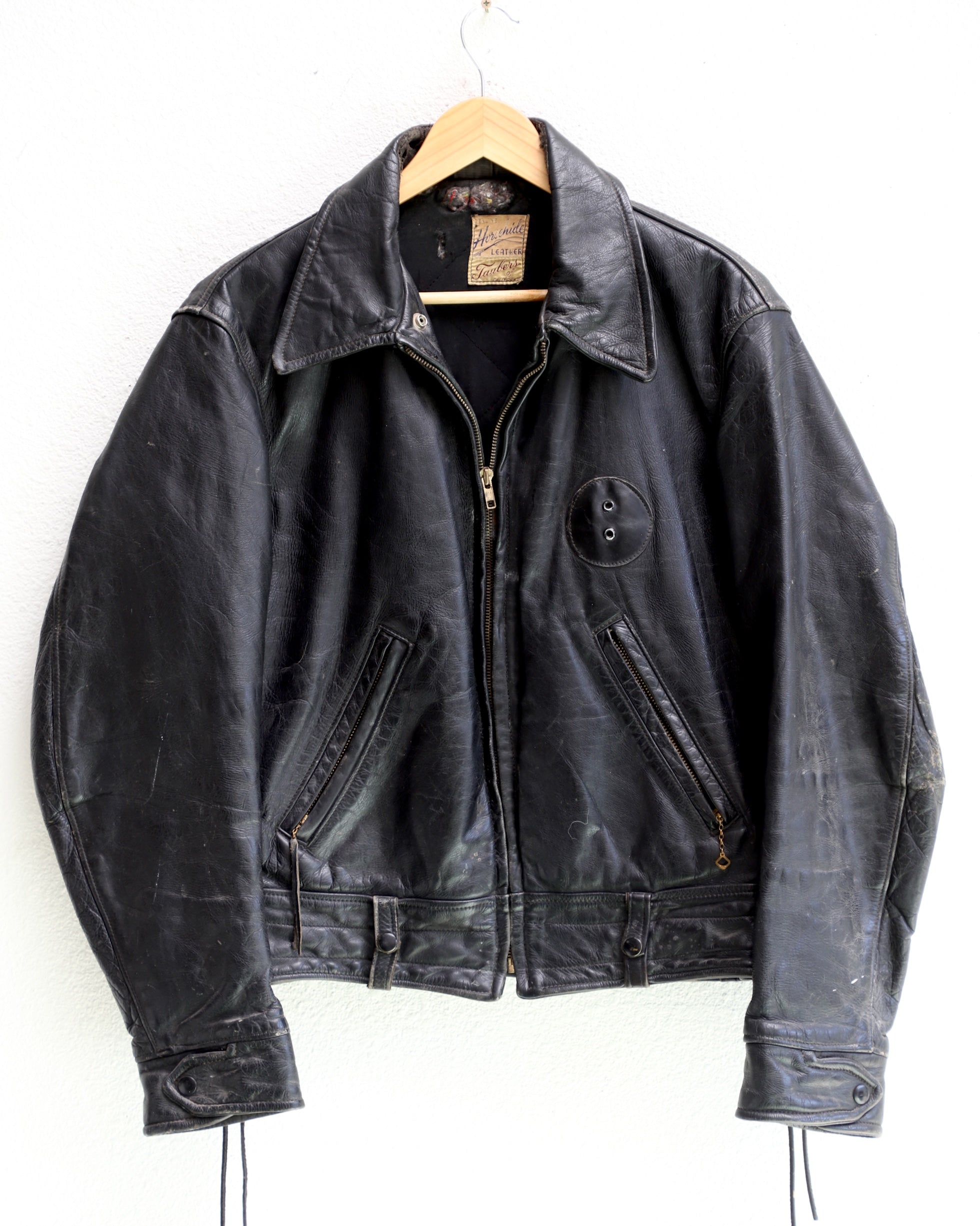 1950s Taubers black horsehide leather jacket with lace-up sides, Western-inspired yoke, and visible signs of wear.