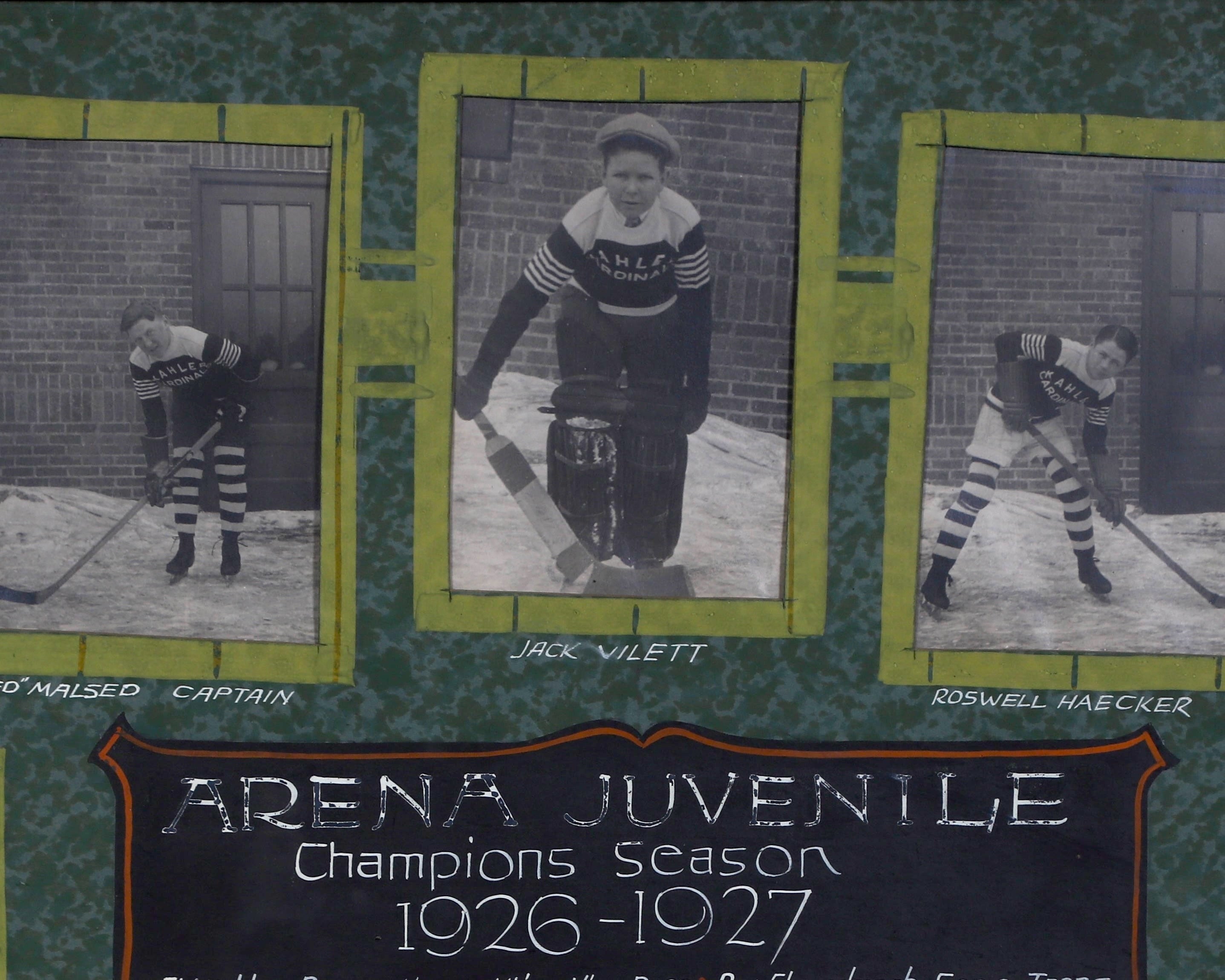 Detail of the framed vintage photo collage of the Arena Juvenile hockey team from the 1926-1927 season. The collage features individual black-and-white photographs of twelve players in their uniforms, arranged around a central plaque with the team’s name and season details. The frame is wooden with a green matt as background and each player’s name is displayed beneath their photo.