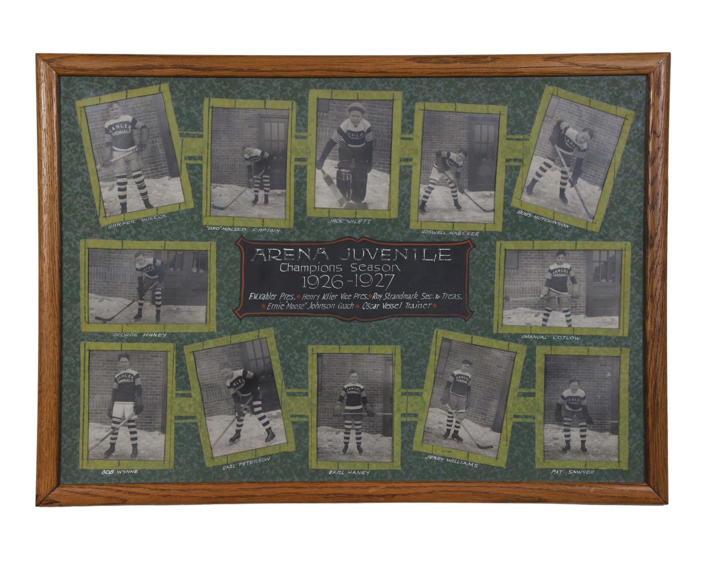 Framed vintage photo collage of the Arena Juvenile hockey team from the 1926-1927 season. The collage features individual black-and-white photographs of twelve players in their uniforms, arranged around a central plaque with the team’s name and season details. The frame is wooden with a green background and each player’s name is displayed beneath their photo.