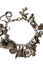 Silver charm bracelet with various charms on a white background