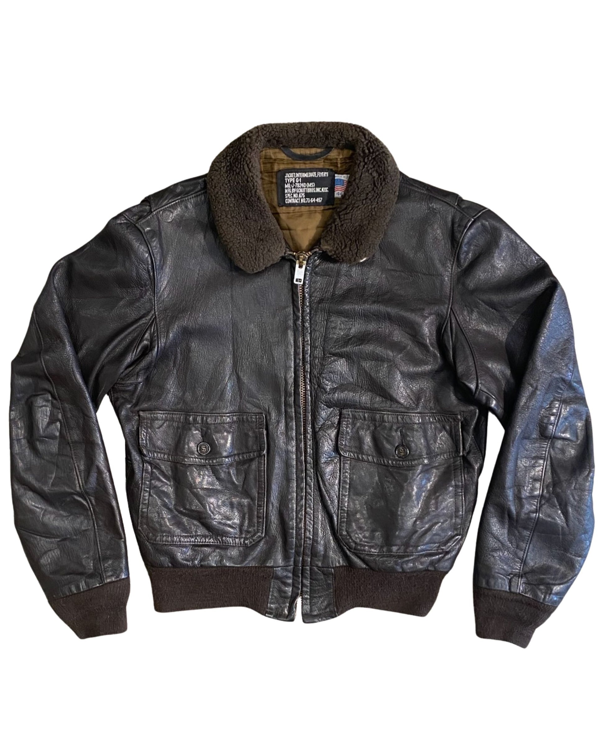 Close-up of original military label inside 1964 Schott Bros. G-1 flight jacket reading Jacket Intermediate Flyer's Type G-1 MIL-J-78240 Contract No. 73-64-457, with Made in USA size 44 tag.