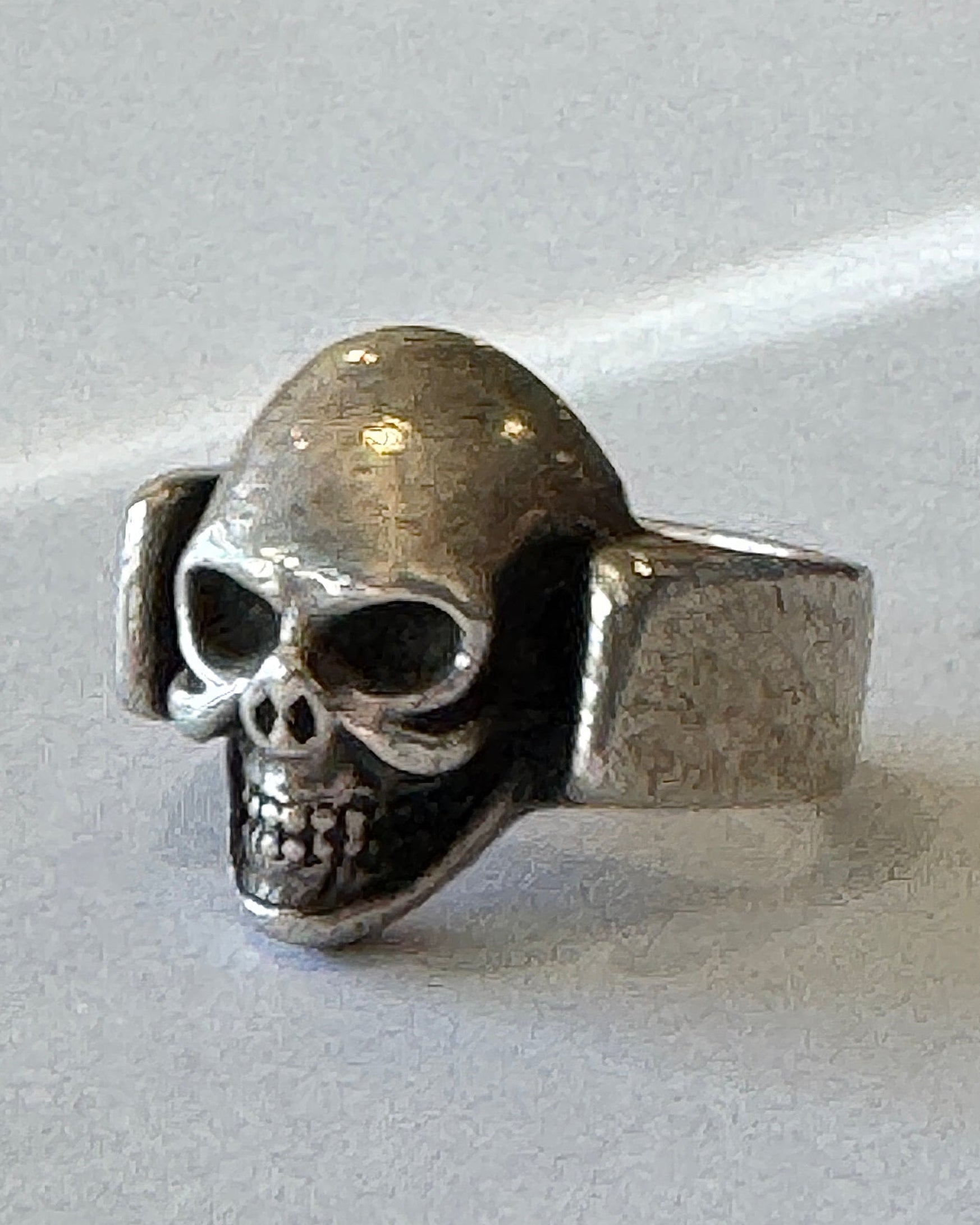 Silver skull ring on a white background.