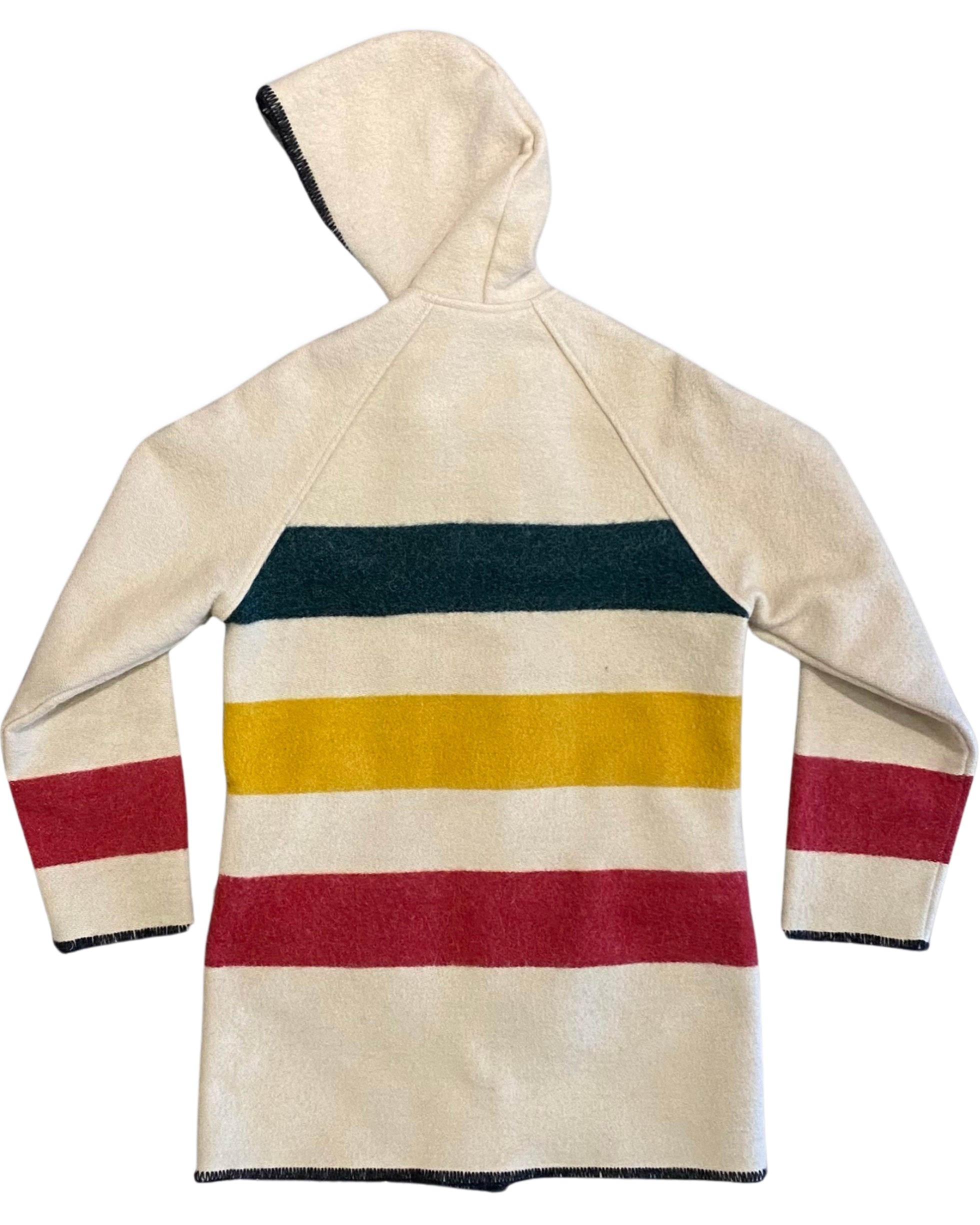 Back view of a cream Woolrich Woman hooded wool coat with green, yellow, and red horizontal stripes and black whipstitched edging.