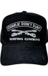 Black cap with 'Charlie Don't Surf' and 'Surfing Cowboys' text on a white background