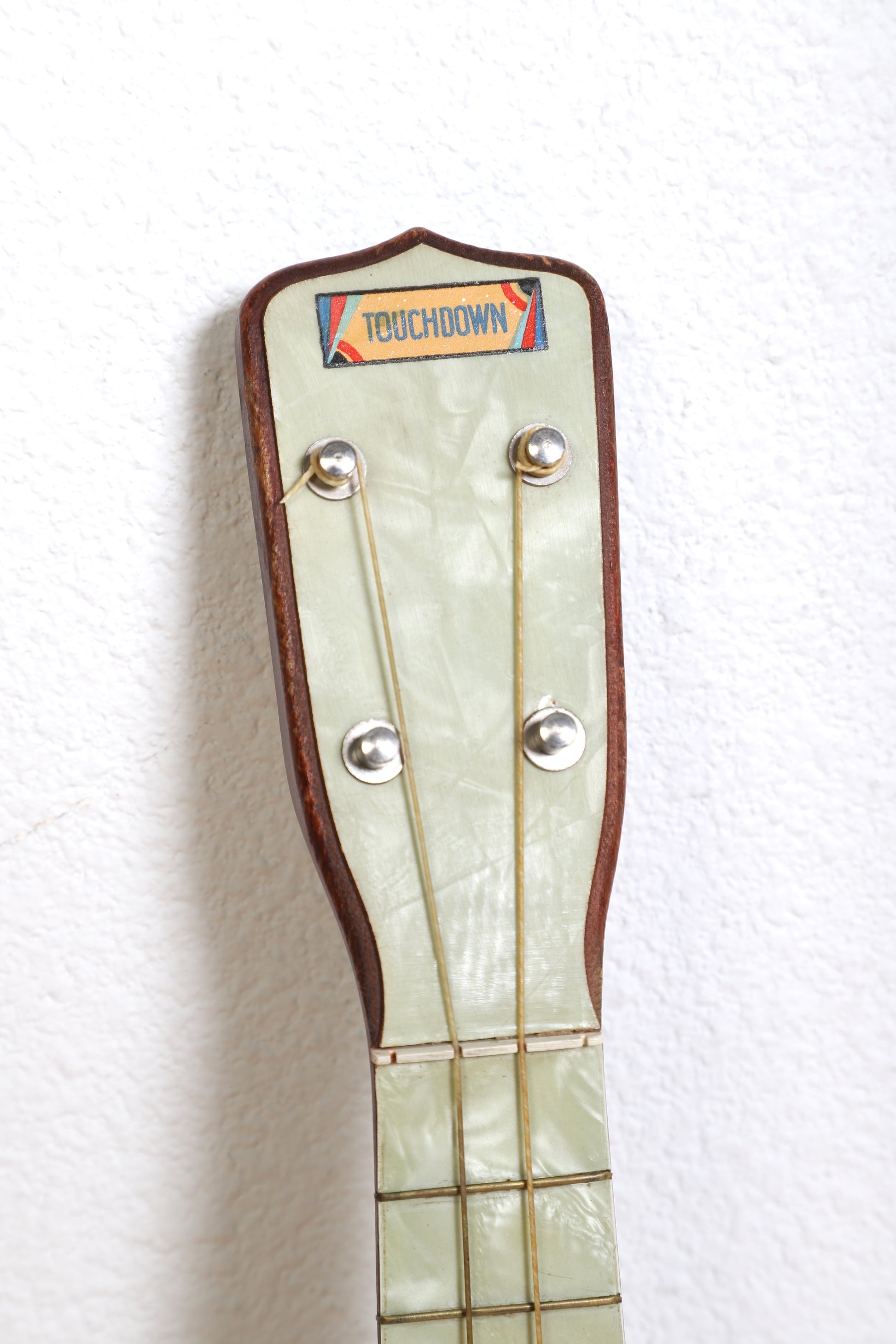 1920s Touchdown ukulele faux pearl fretboard.