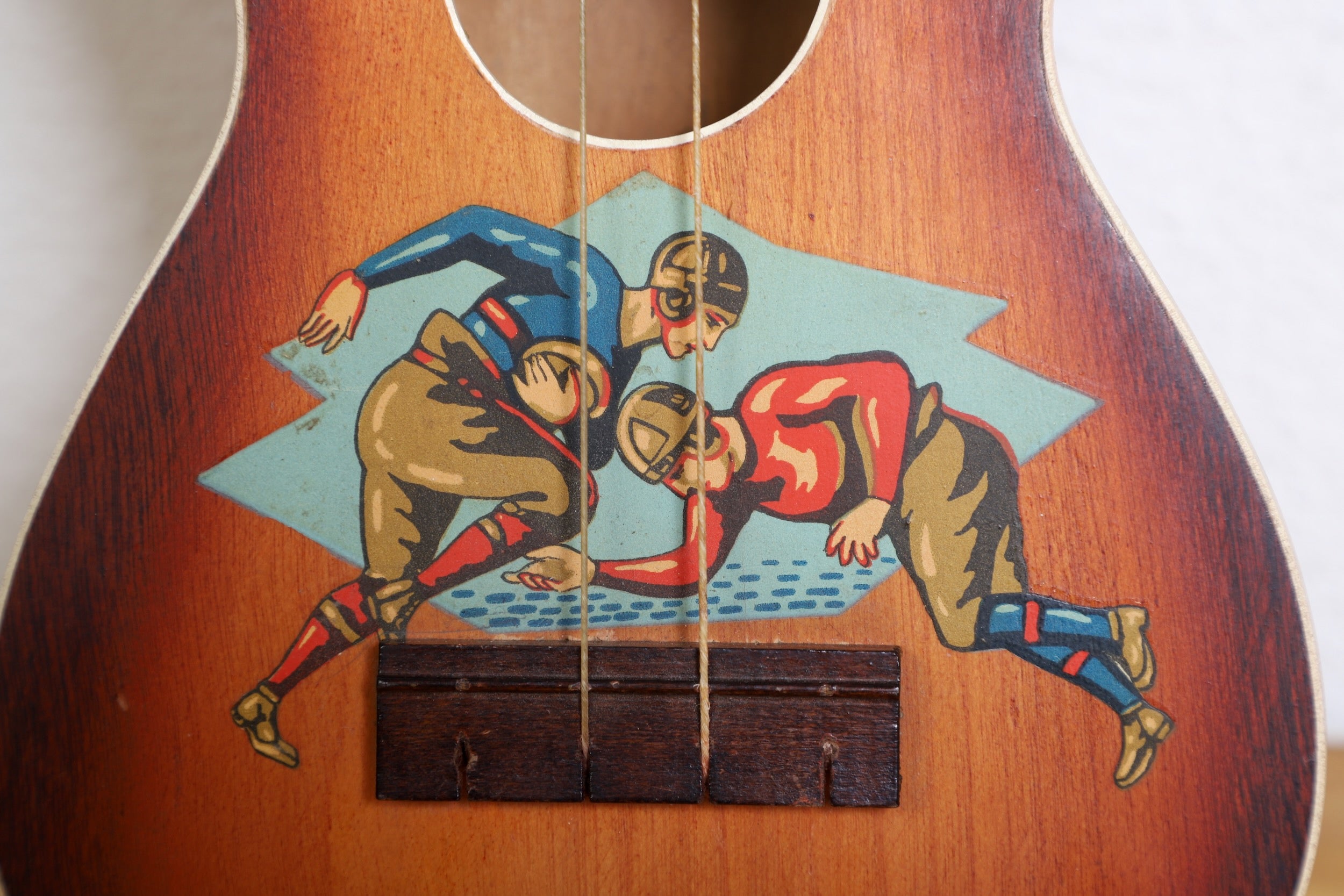  Close-up of Touchdown ukulele headstock with sports-themed inlays.