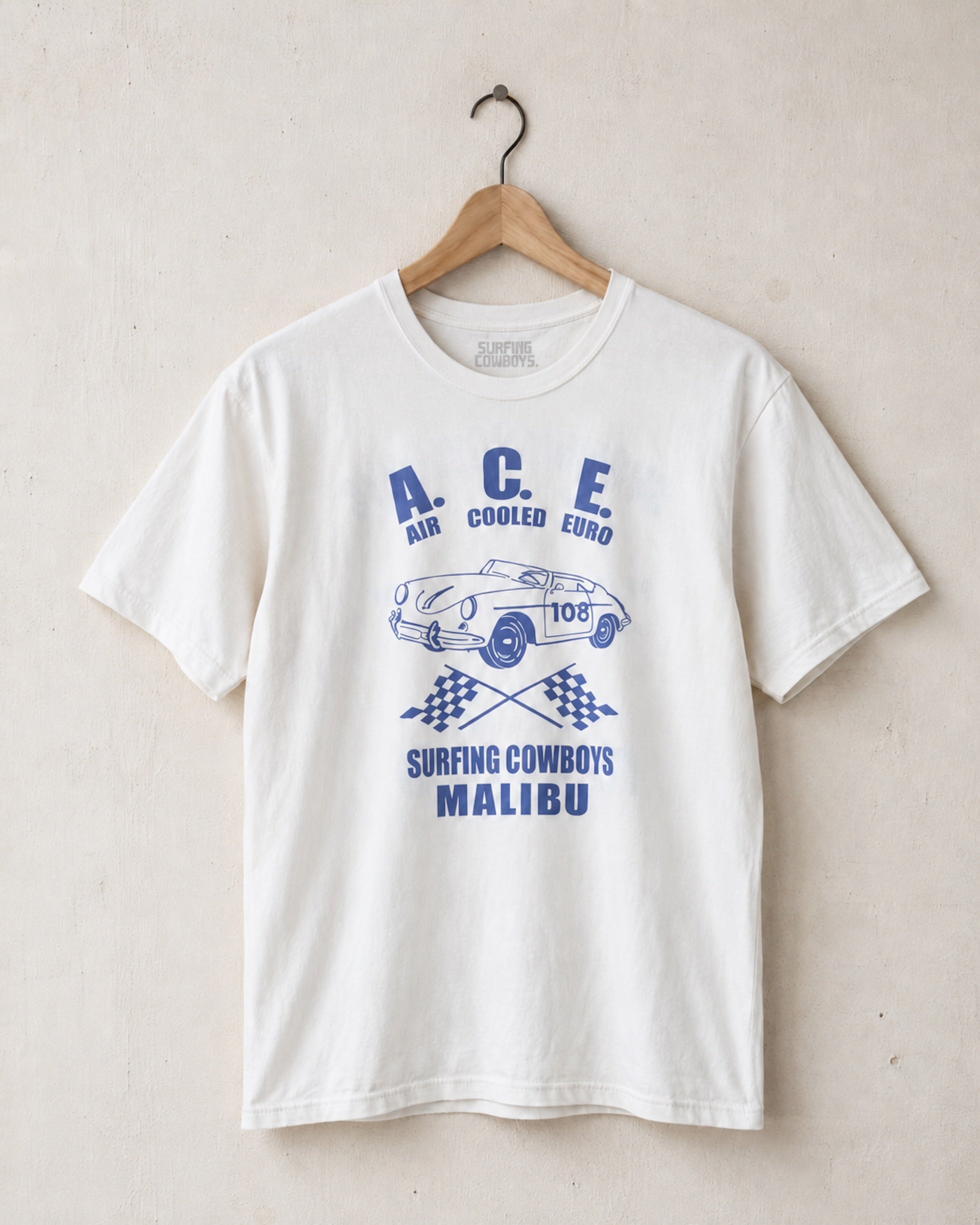 White t-shirt with blue graphic design of a vintage Porsche on a beige background