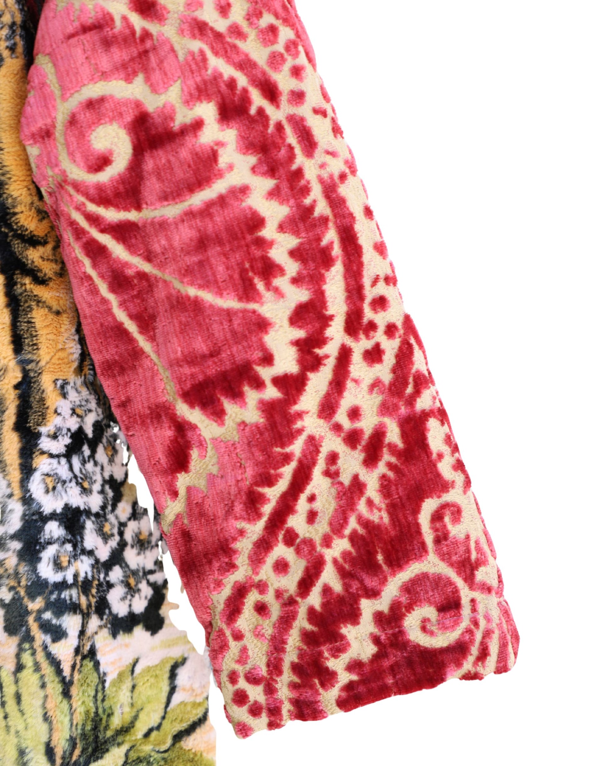 Artisan tapestry coat with stag and deer design, red velvet sleeves, and fringe hem. Handmade one-of-a-kind outerwear in vivid colors.