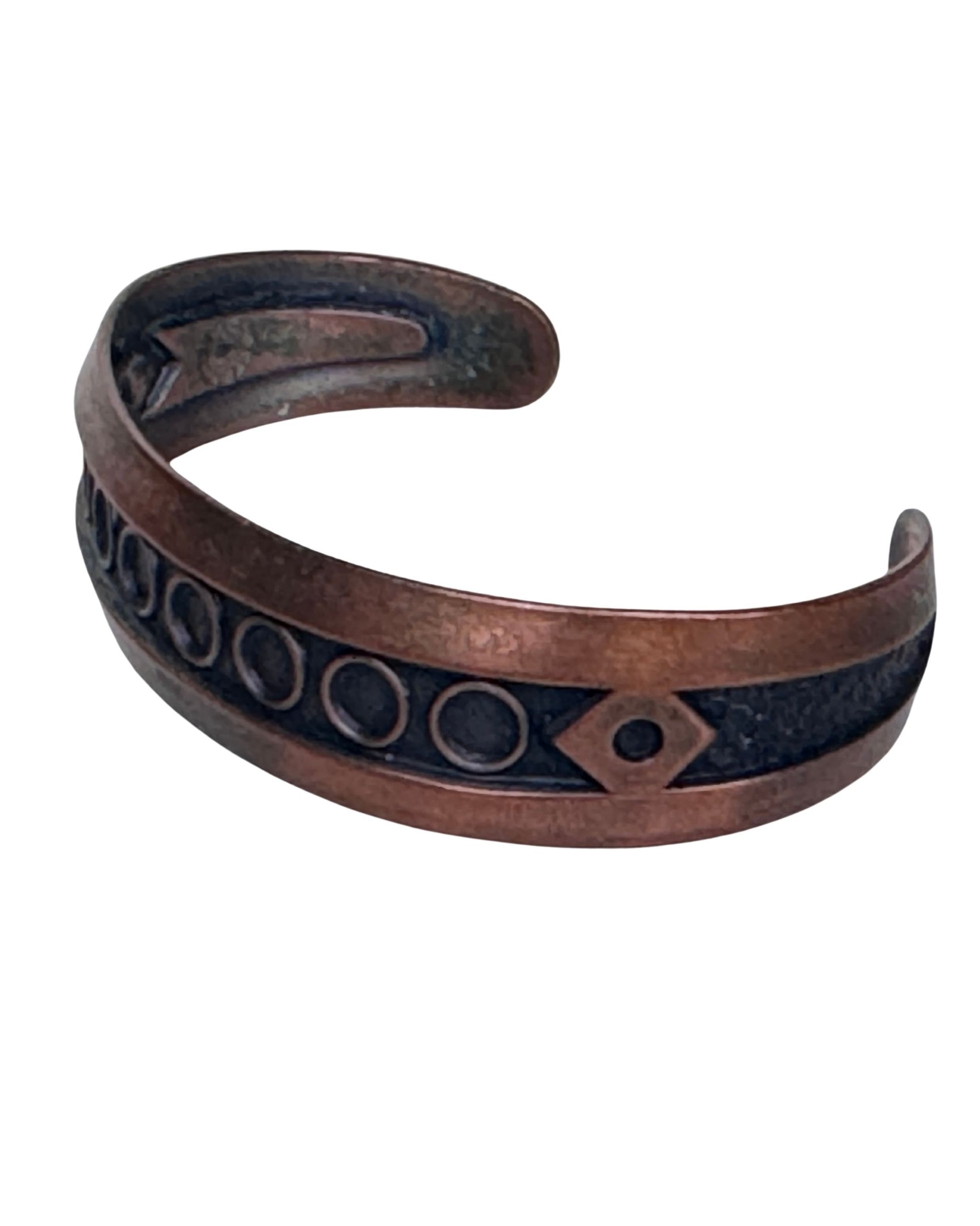 Angled view of vintage Bell Trading Post copper cuff bracelet showing darkened recessed design and warm copper finish.