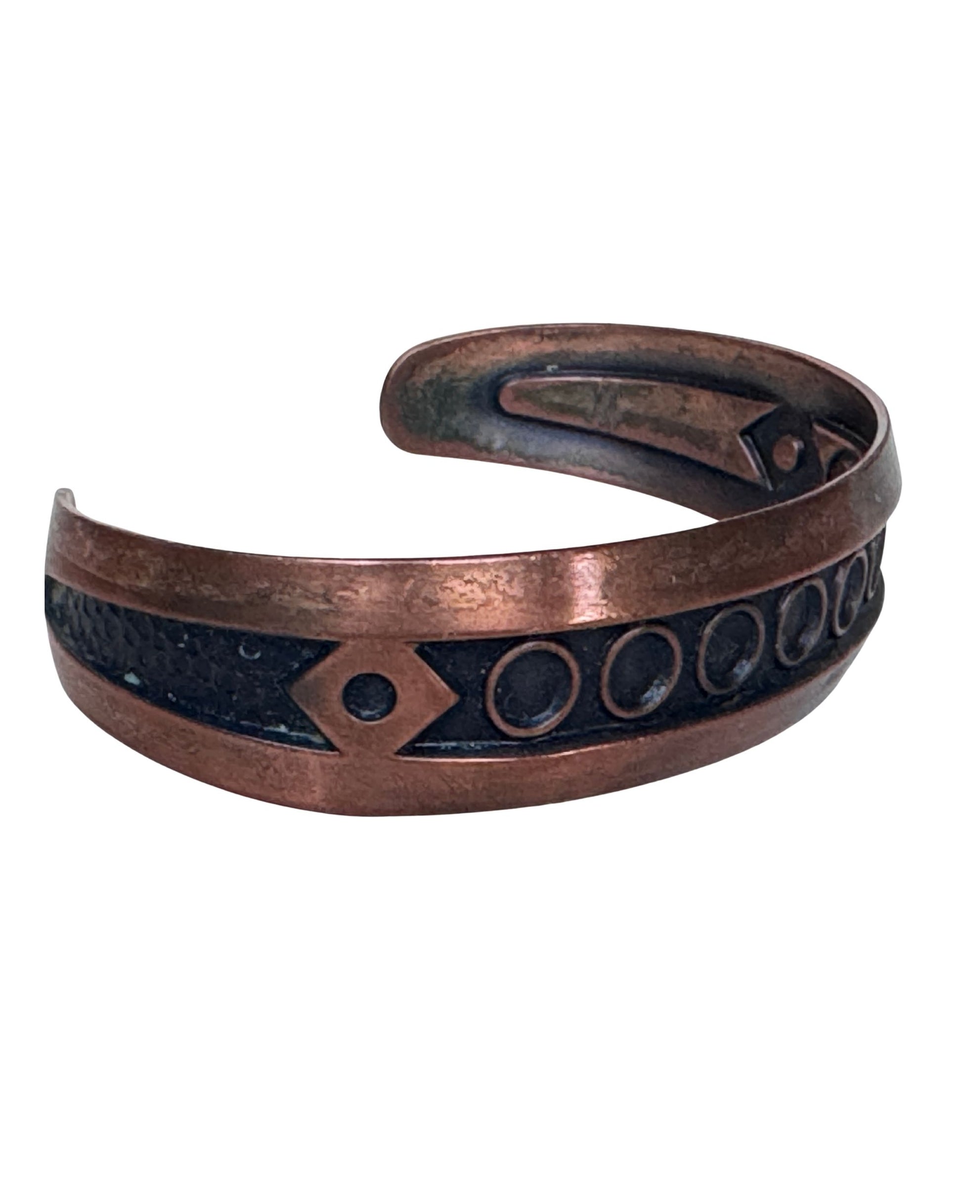 Angled view of vintage Bell Trading Post copper cuff bracelet showing darkened recessed design and warm copper finish.