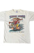 Front view of an aged white short-sleeve T-shirt with a colorful “Think Fast!” monster drag-racing graphic and visible marks below the print.