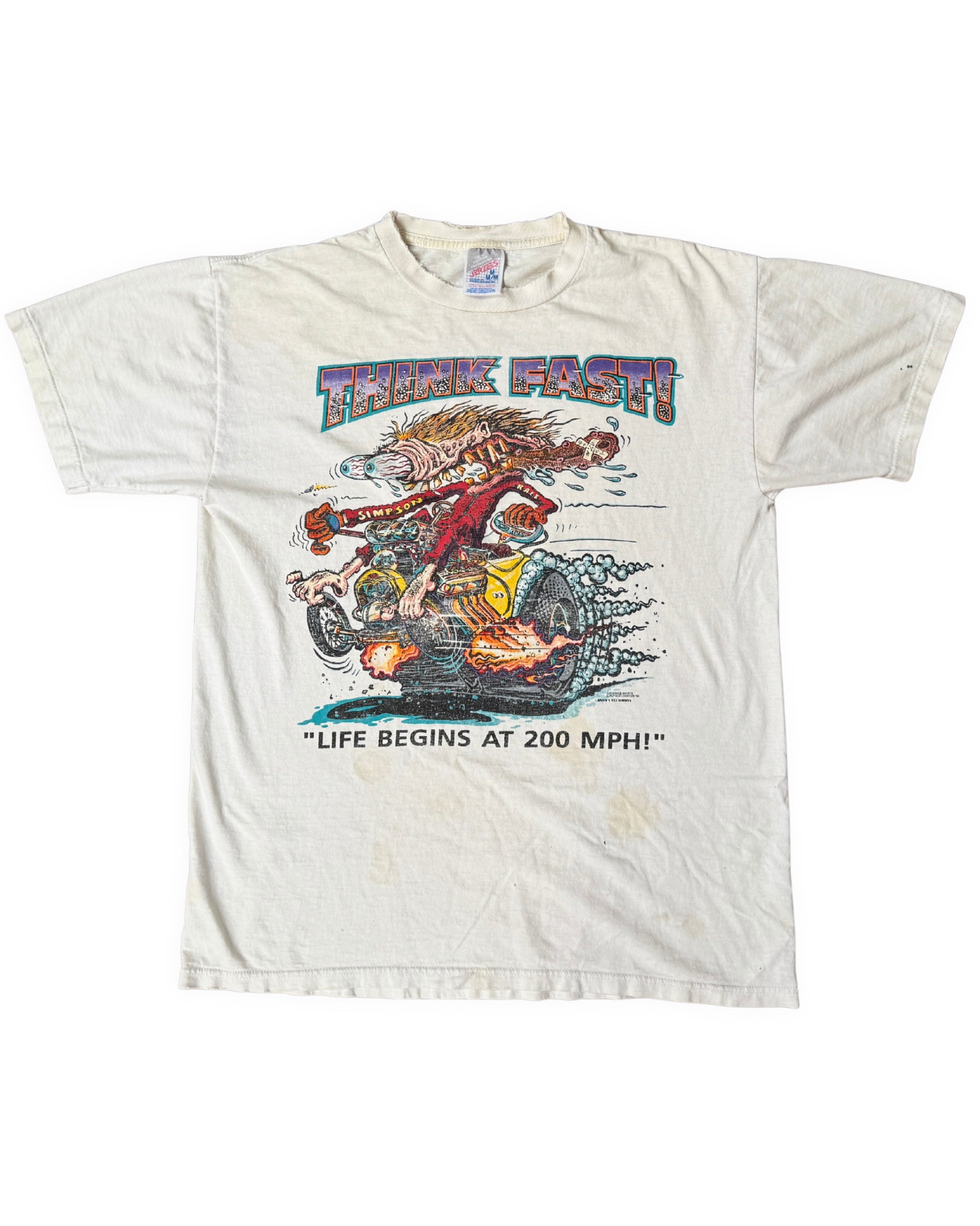 Front view of an aged white short-sleeve T-shirt with a colorful “Think Fast!” monster drag-racing graphic and visible marks below the print.