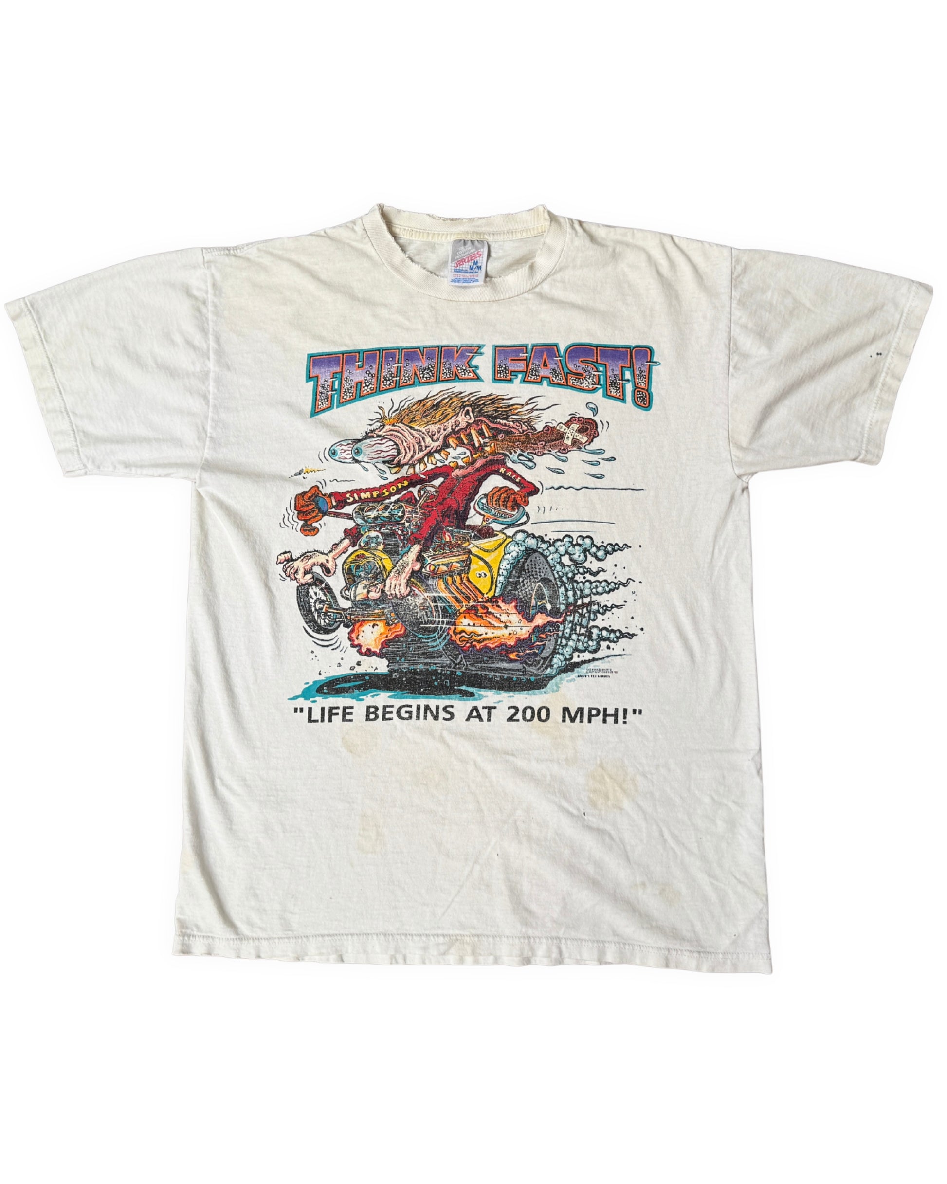 Front view of an aged white short-sleeve T-shirt with a colorful “Think Fast!” monster drag-racing graphic and visible marks below the print.