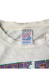 Close-up of the frayed ribbed neckline and Fruit of the Loom Medium label marked 100% cotton and Made in USA.
