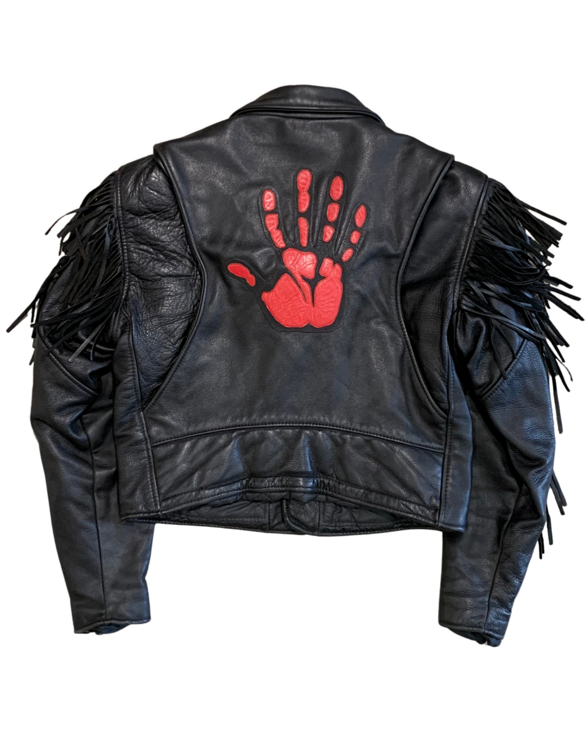 Back view of a black leather motorcycle jacket with long sleeve fringe and a large red hand patch centered on the upper back.
