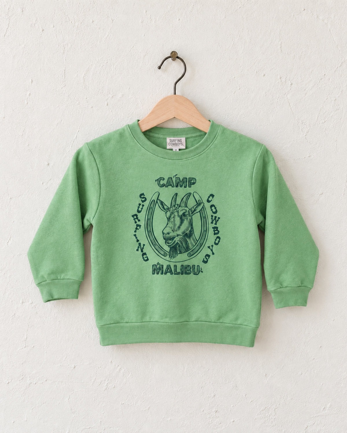 Surfing Cowboys Camp Malibu toddler sweatshirt in Spring Green with navy goat, horseshoe and camp-style graphic.