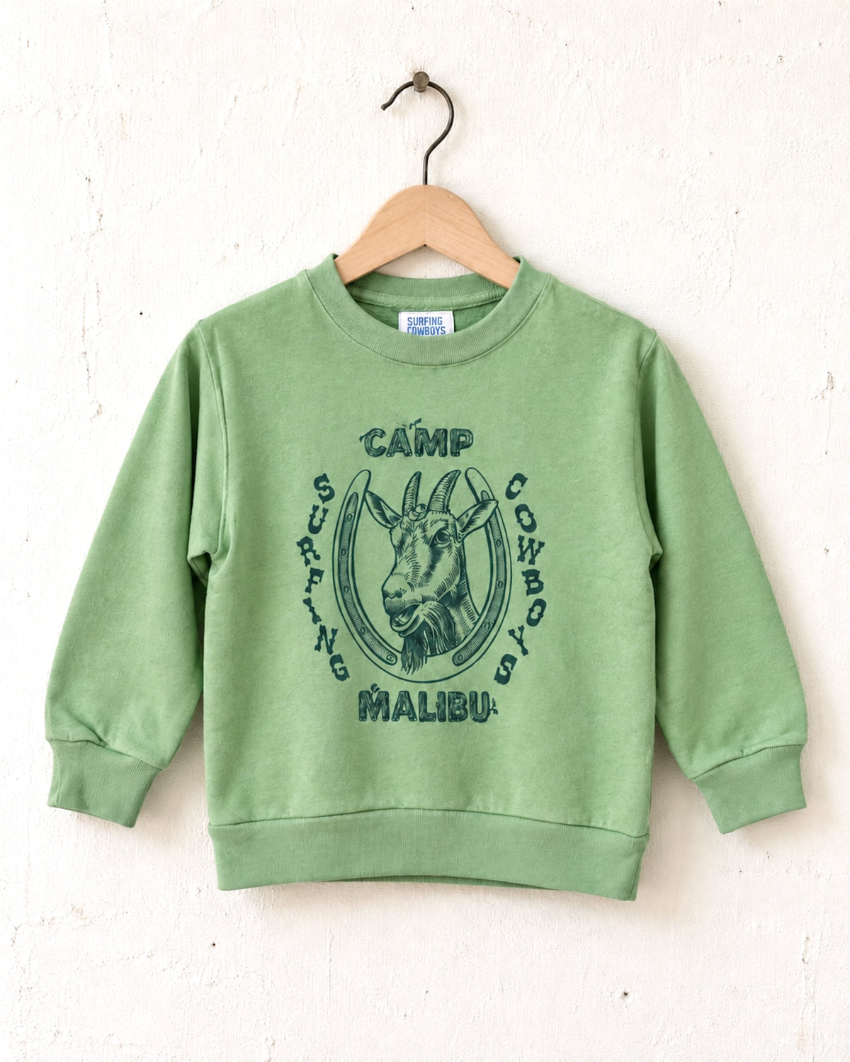 Surfing Cowboys Camp Malibu youth sweatshirt in Spring Green with navy goat, horseshoe and camp-style graphic.