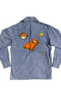Back view of vintage 1980s chambray shirt featuring large orange sports car appliqué, steering wheel patch, and retro automotive accents.