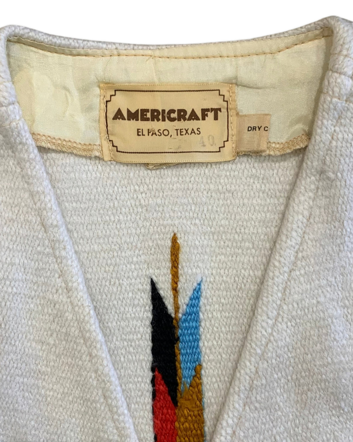 Close-up of the Americraft El Paso, Texas label and the woven fabric and geometric motif of the waistcoat.