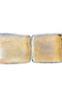 Vintage silver cigarette case with yellow interior on a white background