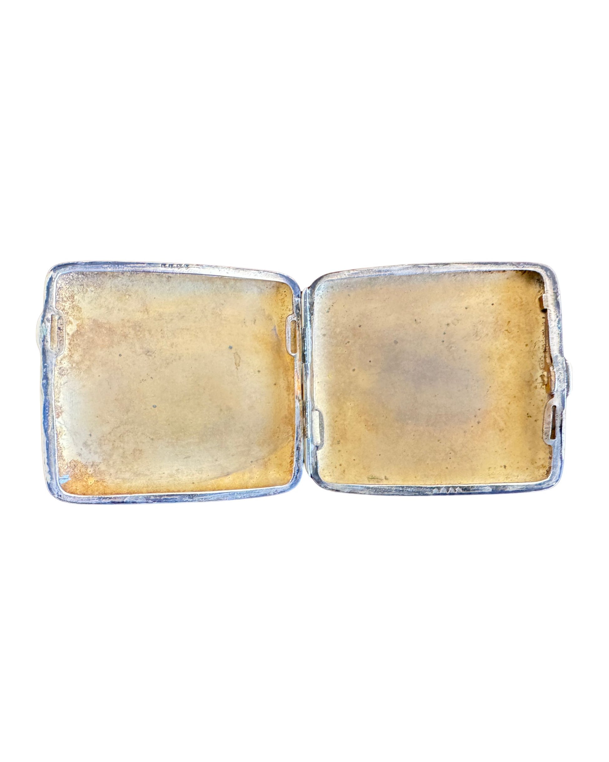 Vintage silver cigarette case with yellow interior on a white background