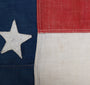 The upclose view of the stitching and star on the 45 Star American Flag from the Spanish American War, Era 1896-1906.