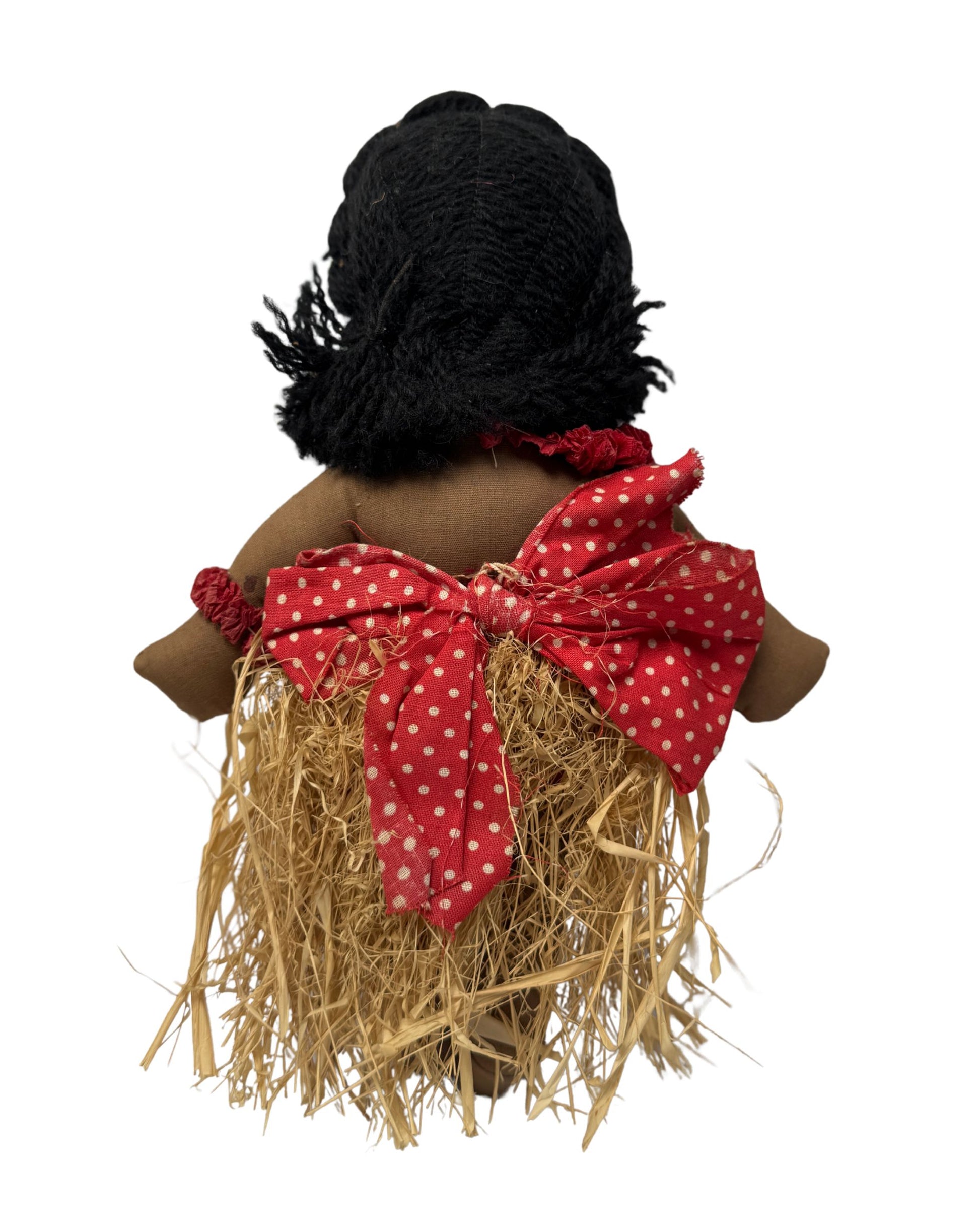 Back of Vintage 1940s cloth Hula doll with showing yarn hair red polka dot bow and raffia grass skirt. 