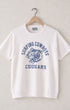 White t-shirt with blue graphic and text on a hanger against a light gray background