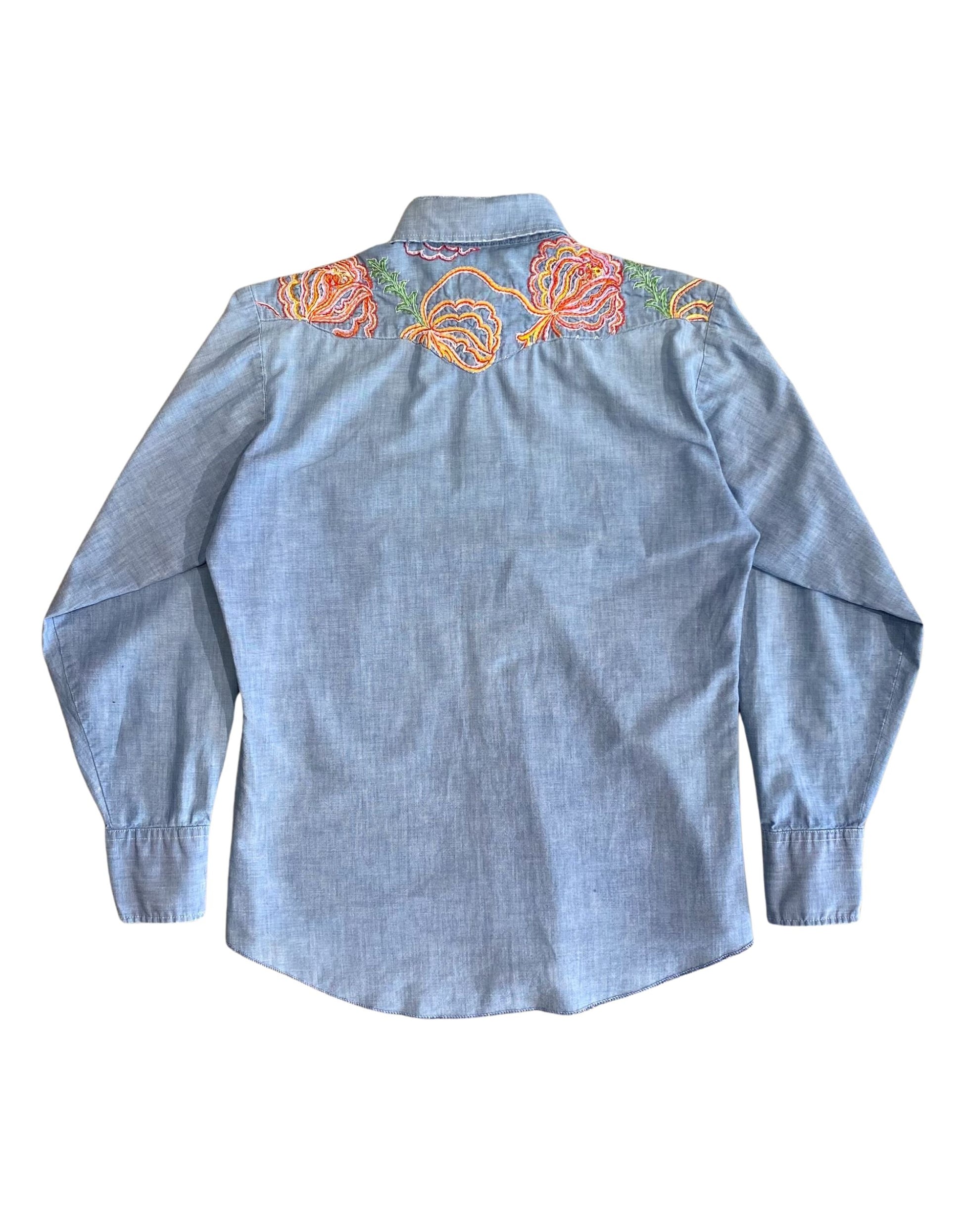 Back view of 1970s embroidered denim shirt showing colorful yoke detail.