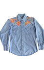 Front view of 1970s snap button denim shirt with vibrant floral embroidery.