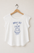 Front view of a vintage-white women’s raglan top with raw cap sleeves, a curved hem, and a faded blue Drag Ski Lake motorboat graphic.