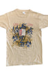 Front view of a beige Duran Duran 1984 tour T-shirt with a blue serpent, stylized mountains, numbers, symbols, and red and blue graphic details.
