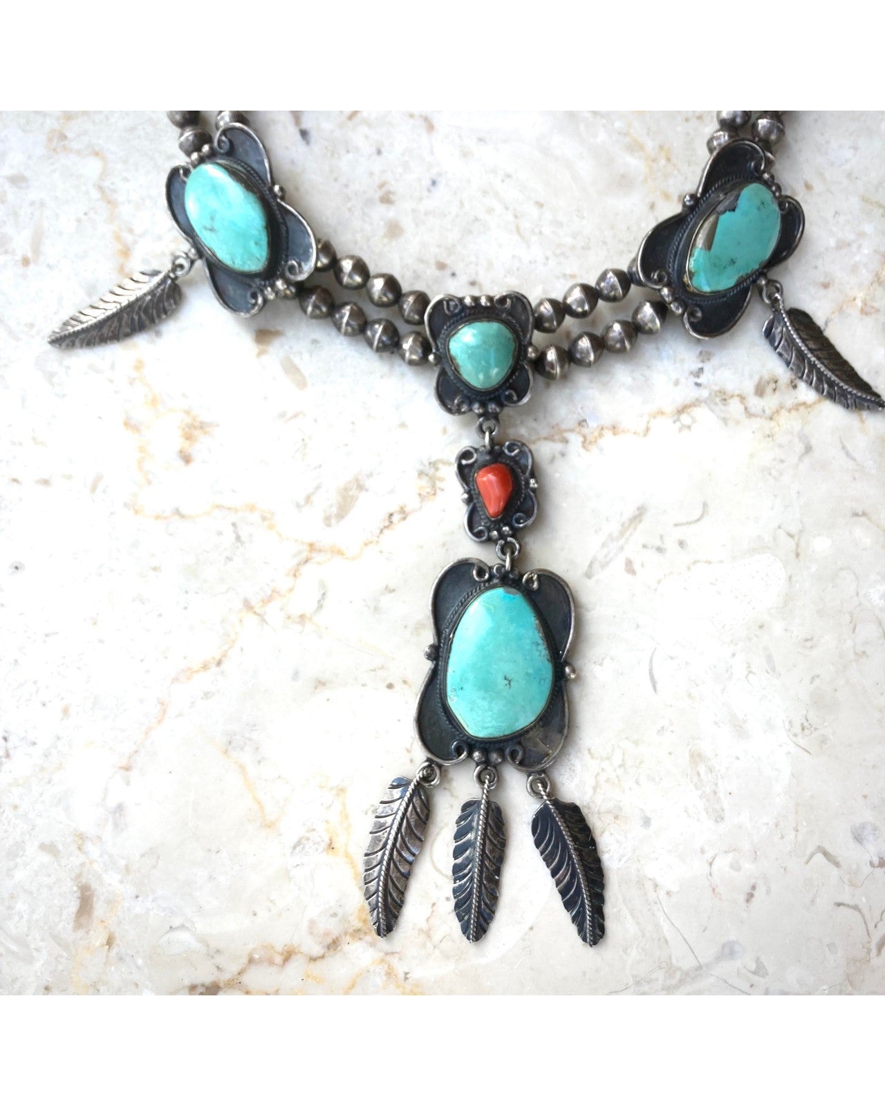 The closeup view of the Old Pawn Necklace with Pendant, Feathers, Turquoise, and Coral, c 1960s.