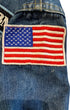Close-up of a red, white, and blue embroidered American Motorcyclist Association patch on faded blue denim.