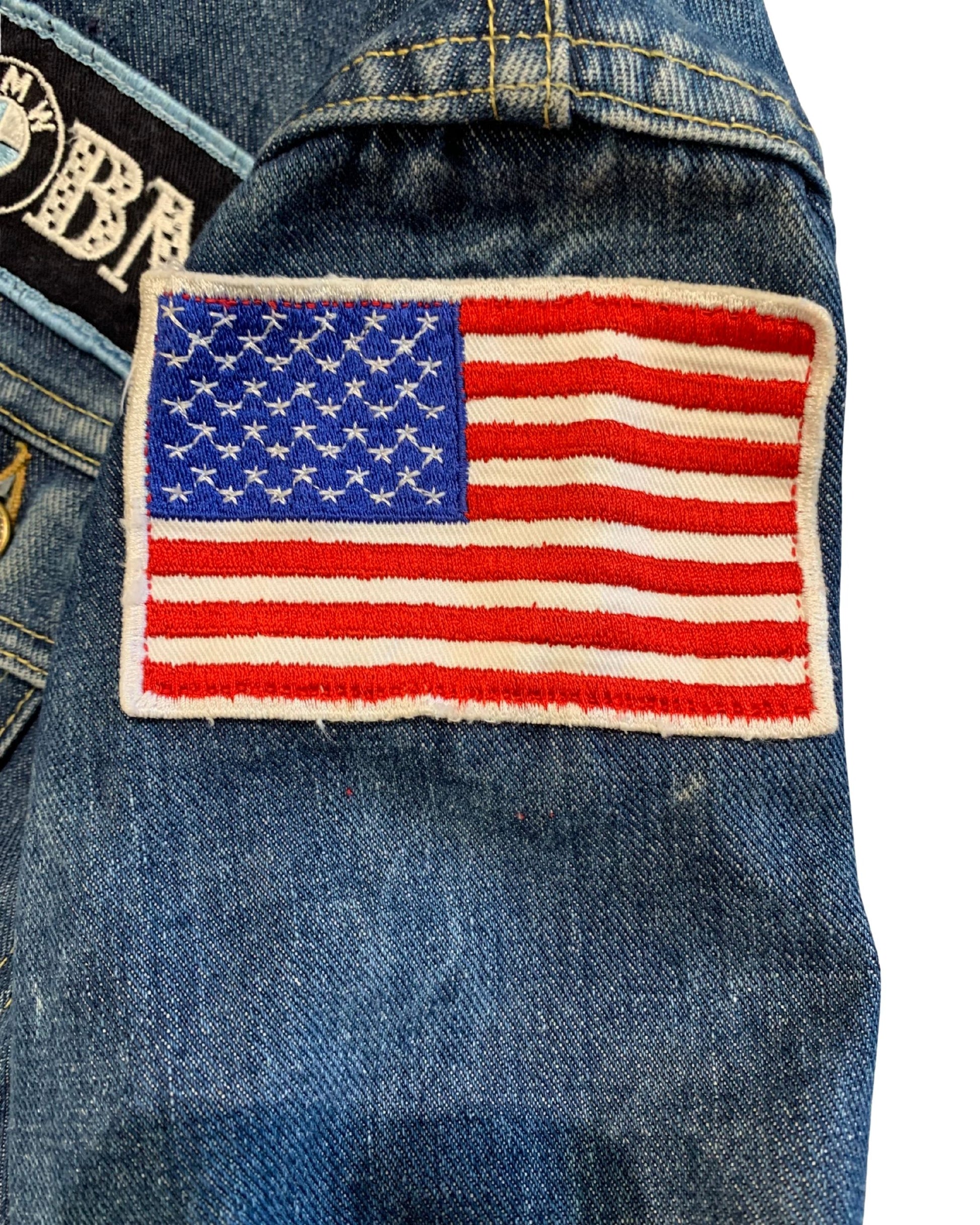 Close-up of a red, white, and blue embroidered American Motorcyclist Association patch on faded blue denim.