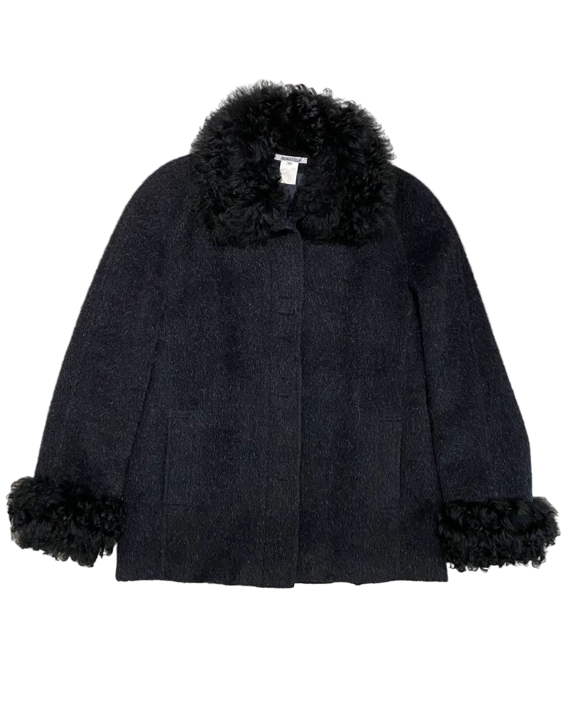 Front view of vintage Georges Rech black coat with curly fur collar and cuffs, made in France, size 42.