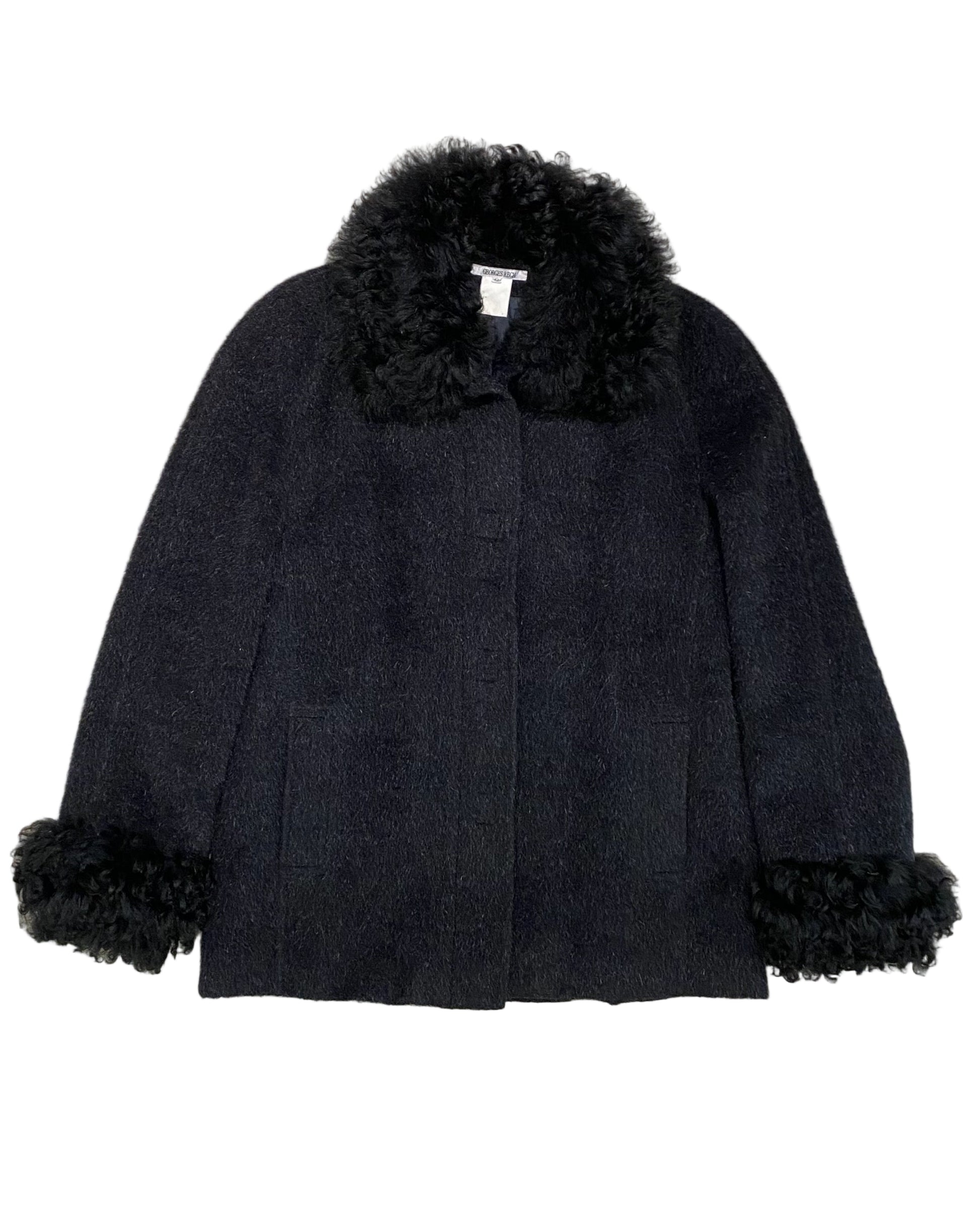 Front view of vintage Georges Rech black coat with curly fur collar and cuffs, made in France, size 42.