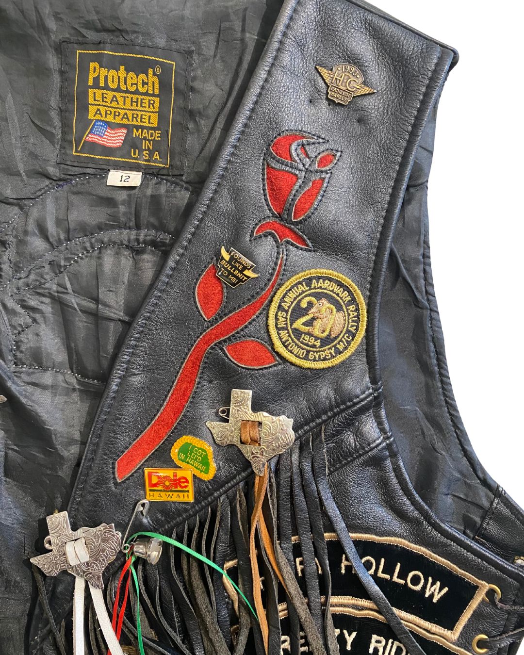 Fringe detail with metal Texas charms and red floral embroidery.