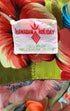 Vintage 1960s Hawaiian Holiday shirt in green, blue, and red rayon with island print. View of label.