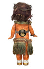 Back view of 1920s mechanical hula girl doll with grass skirt, painted composition face, and wind-up movement - showing wind-up mechanism.
