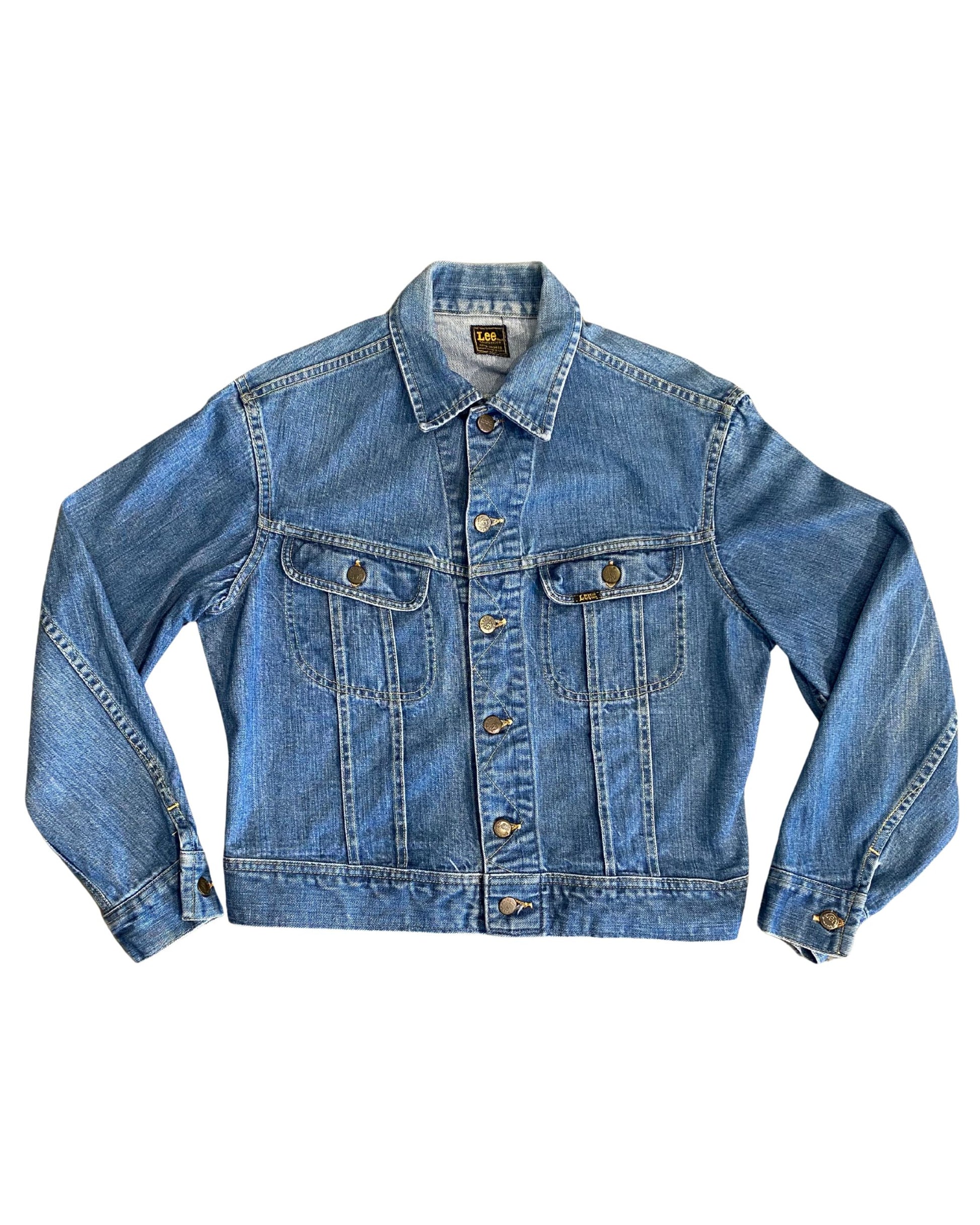 Front of vintage 1970s Lee denim jacket with chest pockets and brass buttons.
