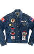 Front view of a faded blue Lee denim jacket covered with BMW, motorcycle rally, American flag, AMA, novelty patches, and vintage pins.
