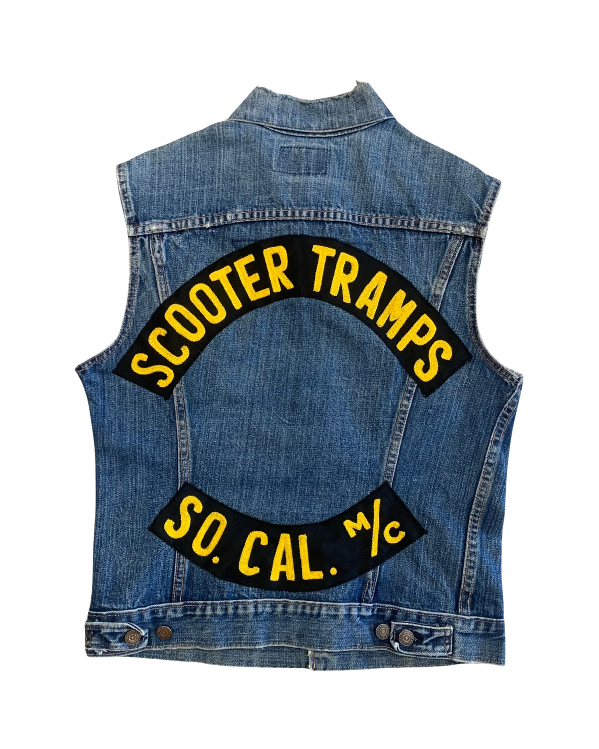 Back view of a faded blue sleeveless Levi’s denim vest with black-and-yellow Scooter Tramps and So. Cal. M/C embroidered patches.
