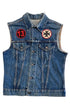 Front view of a faded blue sleeveless Levi’s denim vest with red 13 patch, black cross patch, button front, and chest pockets.