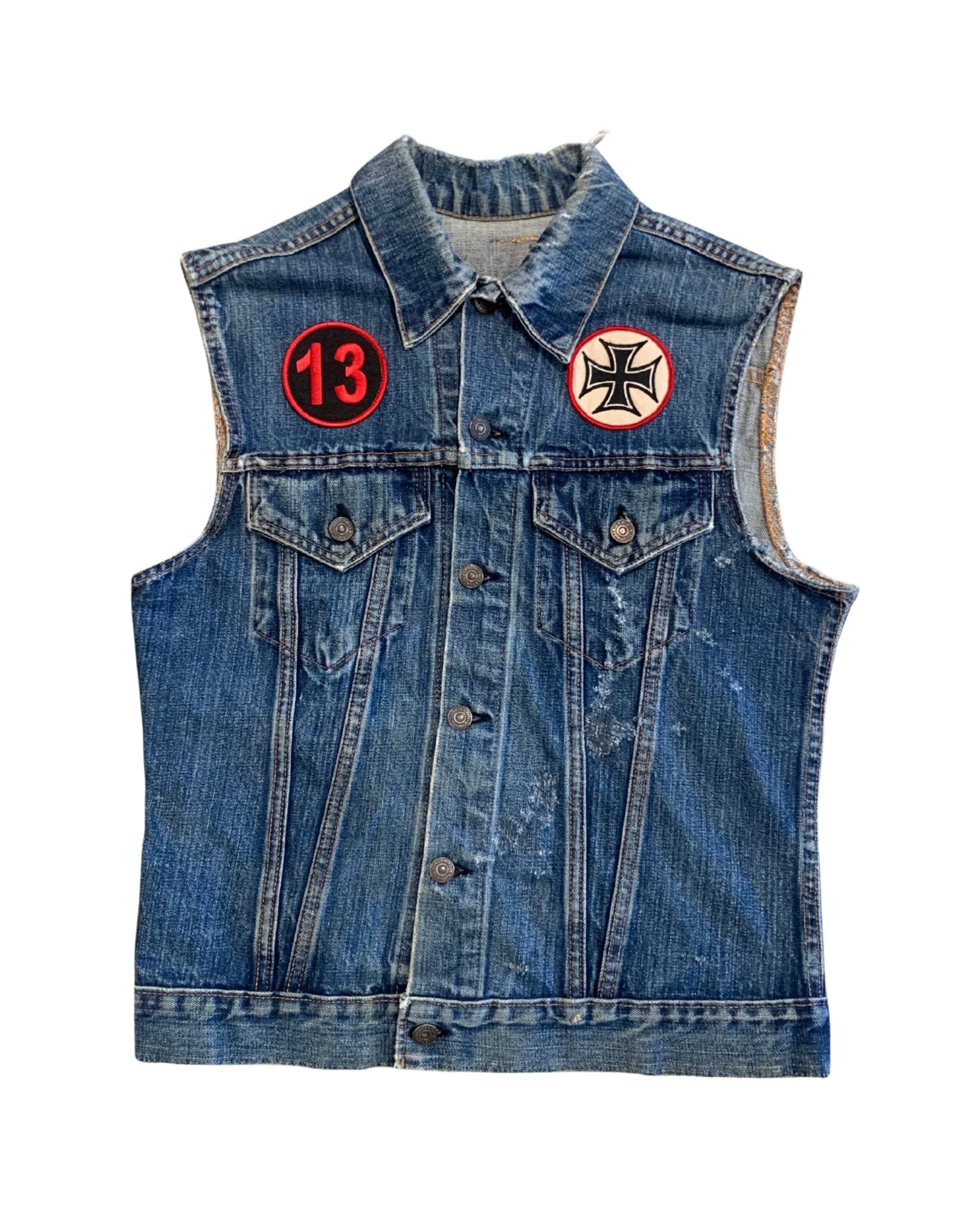 Front view of a faded blue sleeveless Levi’s denim vest with red 13 patch, black cross patch, button front, and chest pockets.