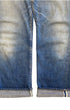 Close-up of the faded lower denim legs with rolled cuffs revealing the selvedge edges and small visible marks.