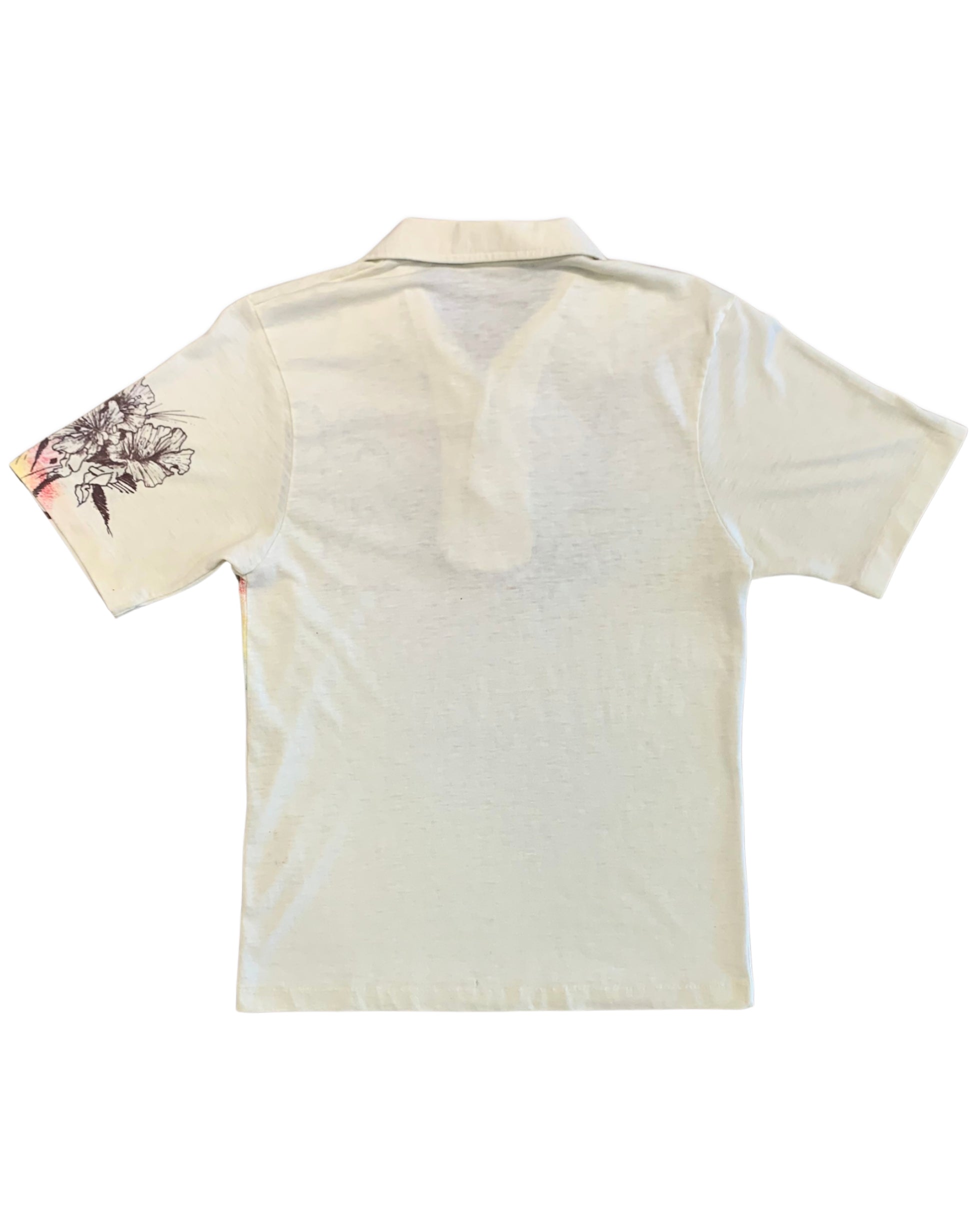Back view of a cream Lightning Bolt short-sleeve polo with a plain body and floral artwork visible on one sleeve.