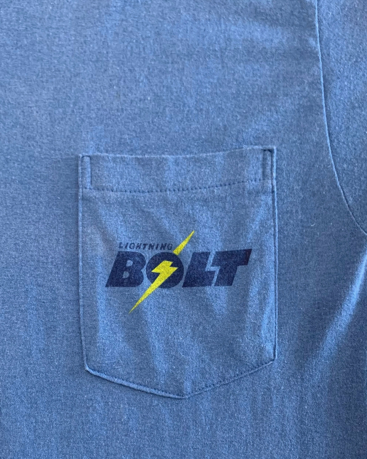 Close-up of the pocket with logo reading Lightning Bolt on an original 1970s vintage heather blue cotton knit shirt.