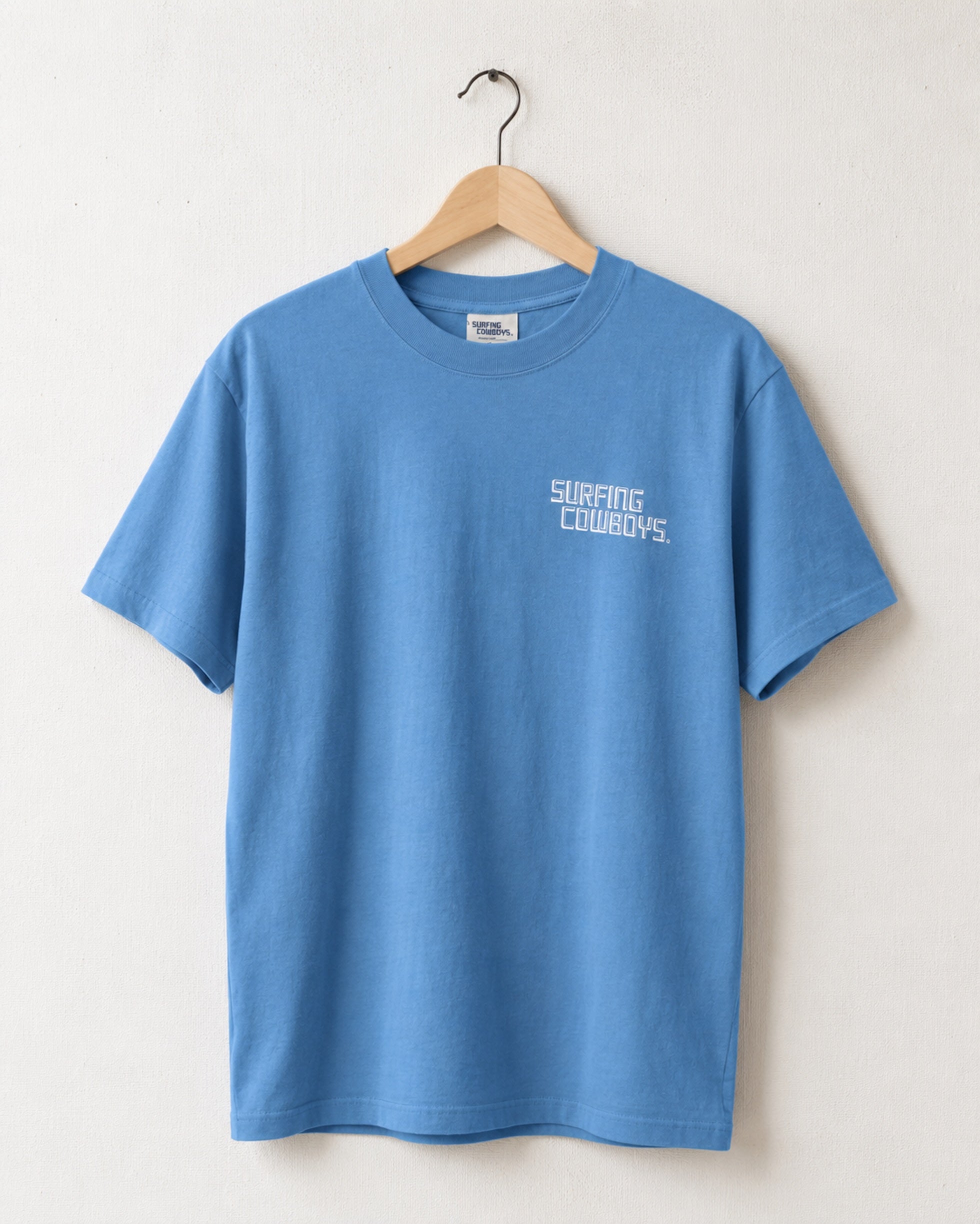 Front of Surfing Cowboys High Crew Cotton Logo T-Shirt in blue -  view of chest logo placement printed in faded soft white.